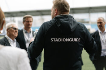 Mann trägt eine schwarze Weste mit der Aufschrift